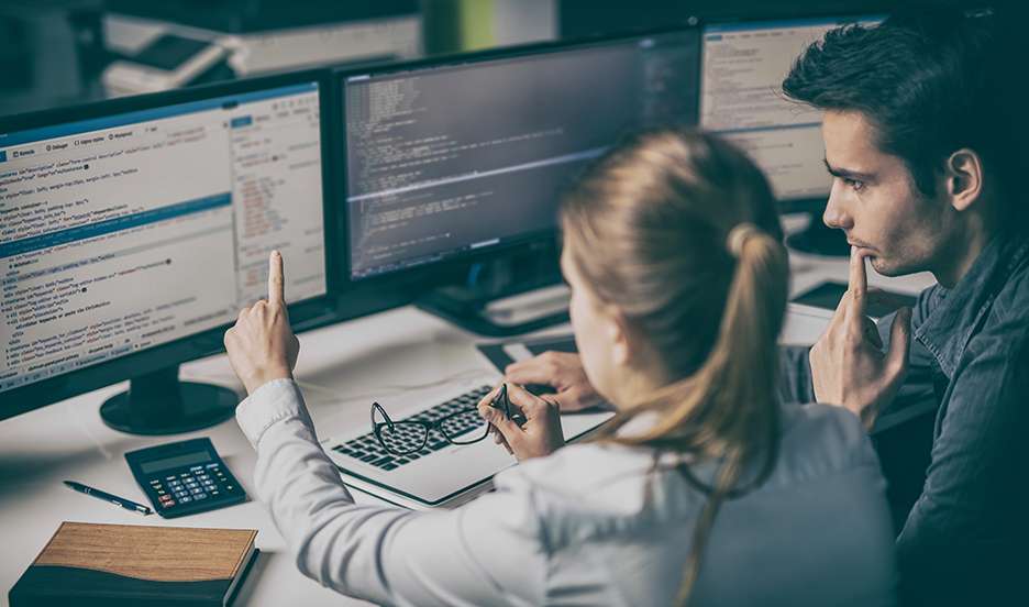 man and woman channel marketing professionals working on a computer together reviewing SPIFF data processing