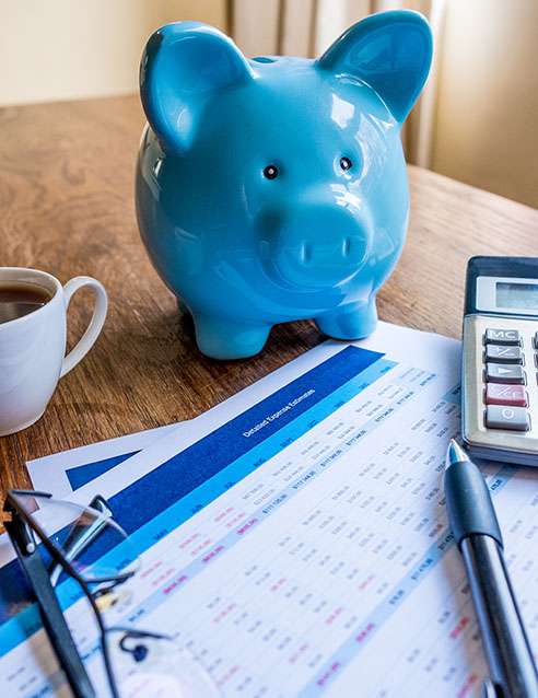 blue piggy bank and documents on desk